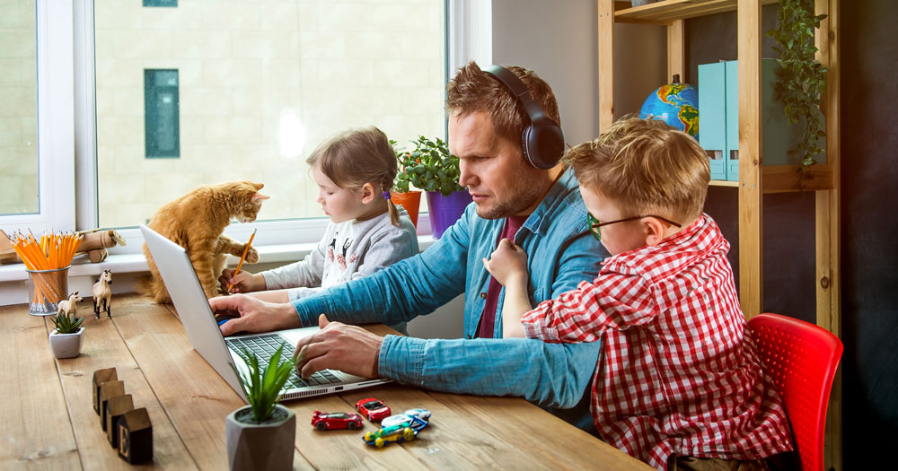 Familiefar har hjemmekontor med barn rundt seg