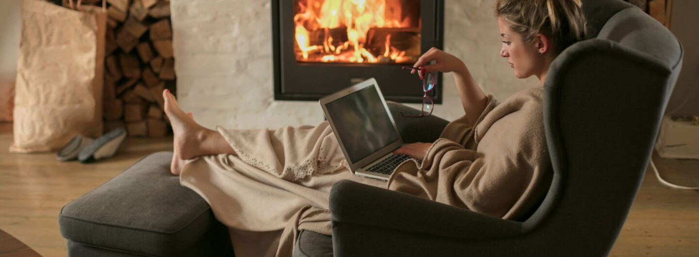 Woman working from home with a fireplace in the background