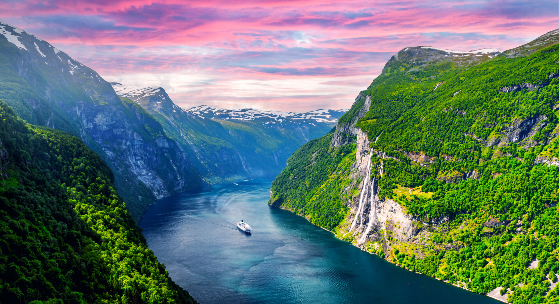 Panoramic view of the Sunnylvsfjord near Geiranger, western Norway, featuring a cruise ship and the famous Seven Sisters waterfalls