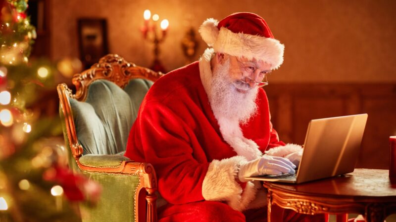 Julenissen foran en PC. Foto: Shutterstock