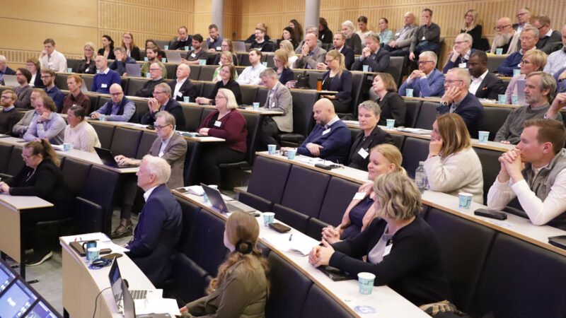 En gruppe mennesker deltar i en konferanse i et auditorie.