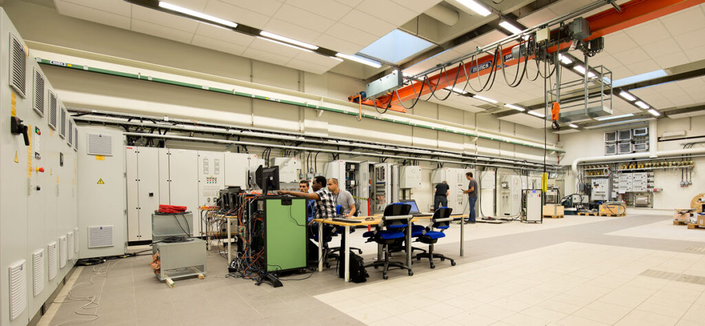 Three people loking at a pc screen in National Smart Grid Laboratory