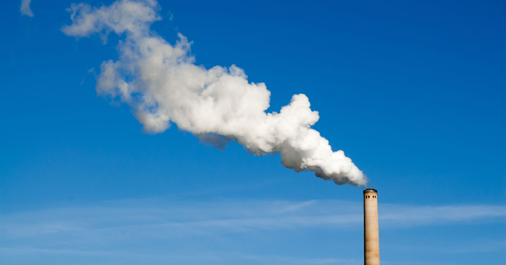 Factory chimney and plume of off-gas.