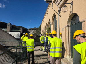 Folk i gule vester ved en kraftstasjon